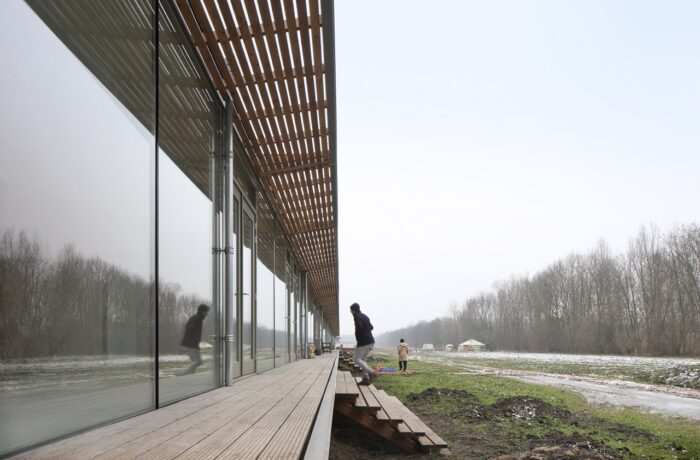 Closeup of timber and glass facade letting in natural lighting, co-living Oosterwold by bureau SLA