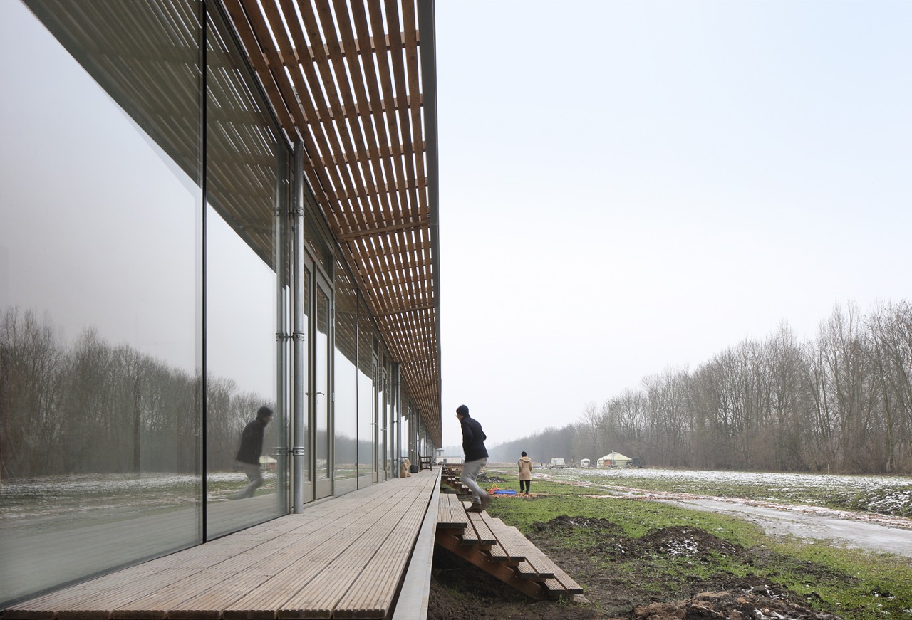 Closeup of timber and glass facade letting in natural lighting, co-living Oosterwold by bureau SLA